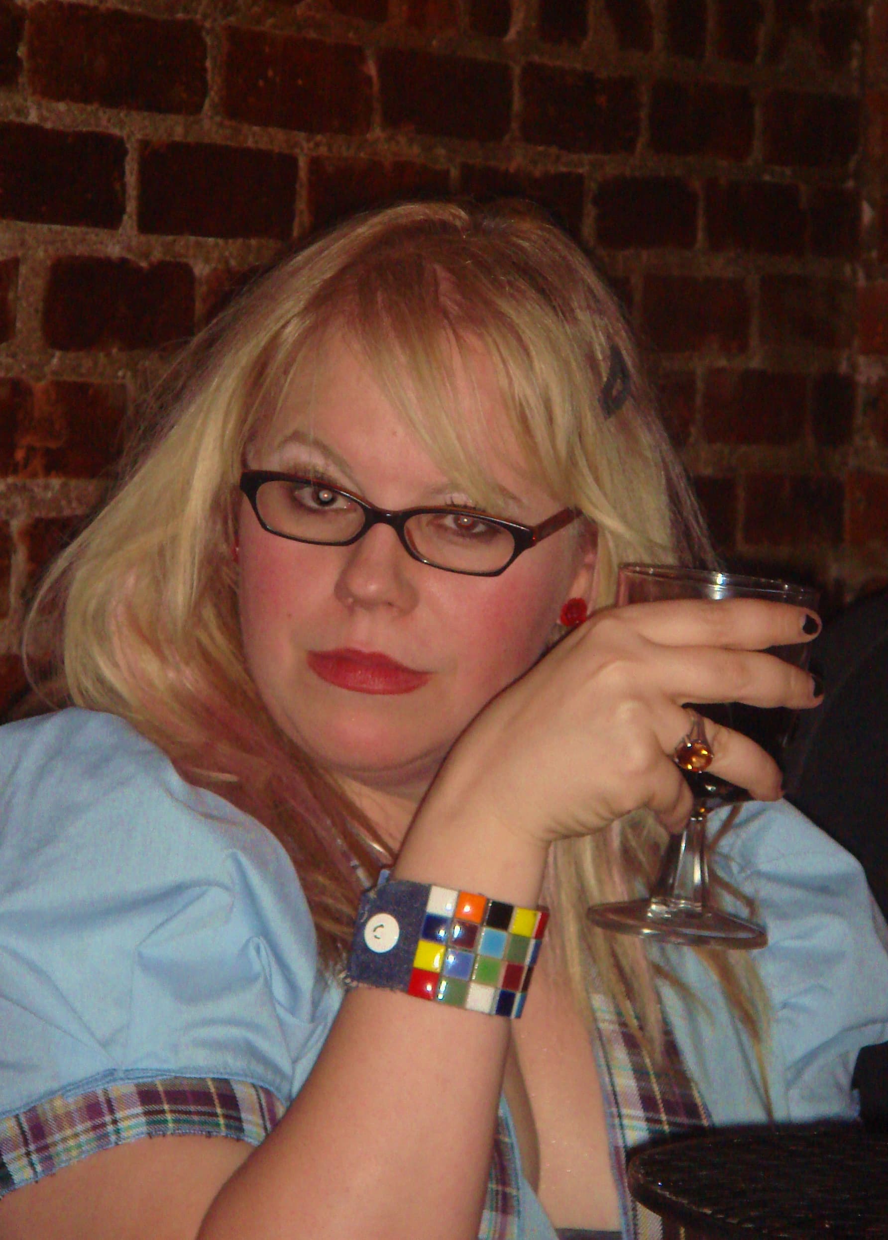 Portrait of Kirsten Vangsness smiling, with a subtle background hint of a TV set